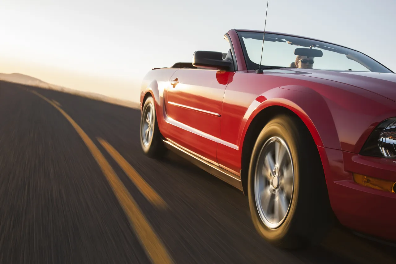 a-low-angle-view-of-a-convertible-sports-car-movin-2023-11-27-05-02-38-utc